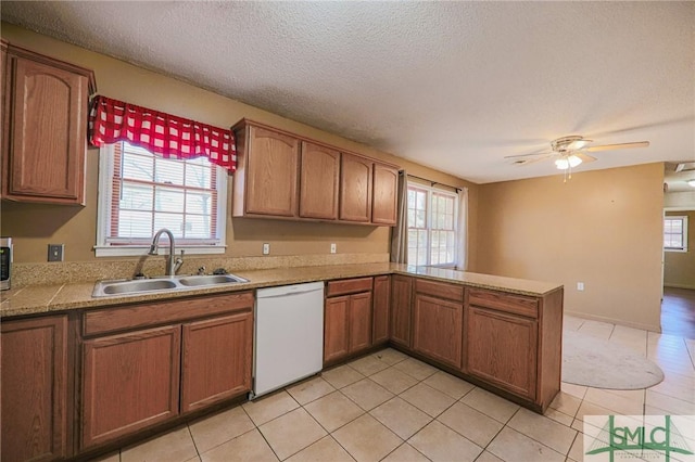 kitchen with a sink, plenty of natural light, a peninsula, and white dishwasher
