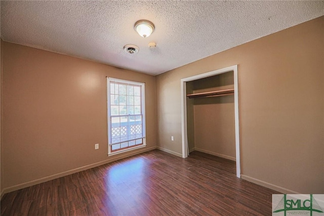 unfurnished bedroom with a closet, visible vents, baseboards, and dark wood-style flooring