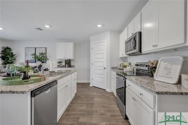 kitchen with visible vents, appliances with stainless steel finishes, dark wood-style floors, white cabinetry, and a sink
