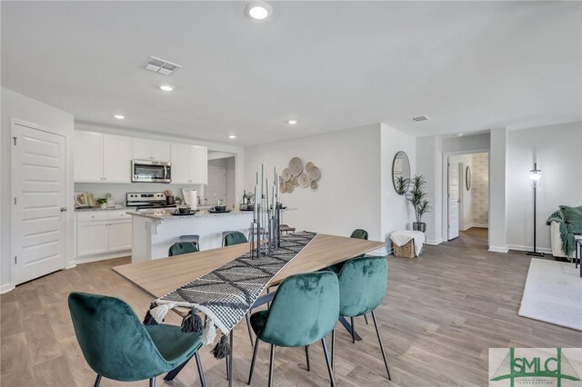 dining area with recessed lighting, visible vents, and light wood-style flooring
