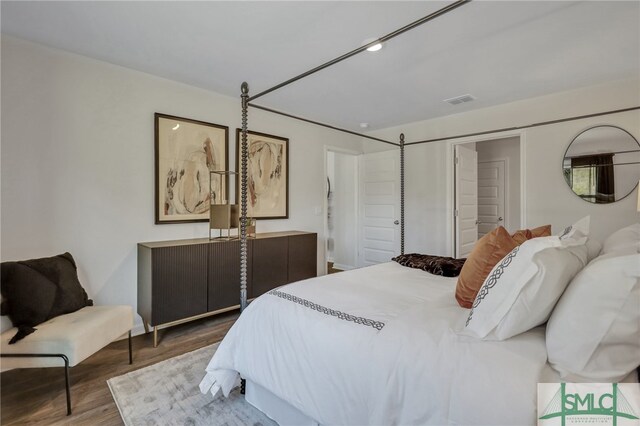 bedroom featuring visible vents and wood finished floors
