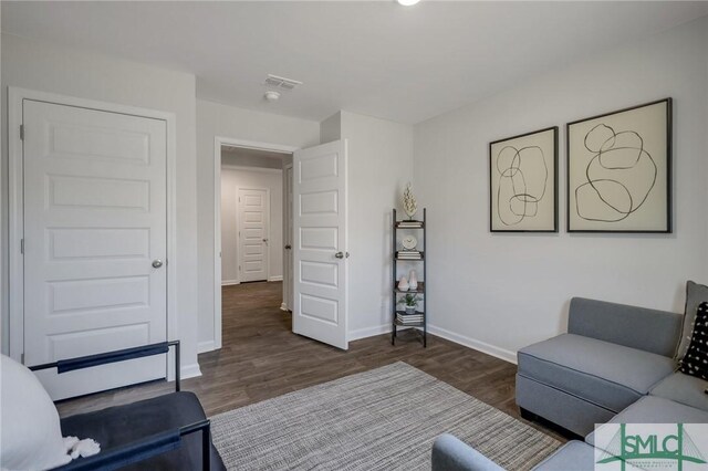living room featuring visible vents, wood finished floors, and baseboards