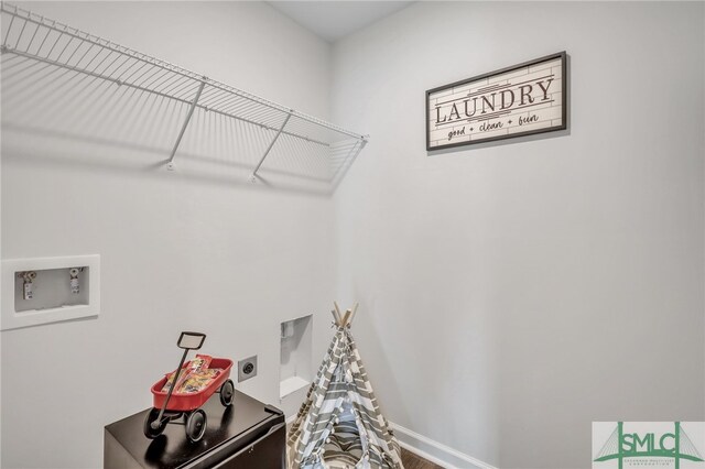 laundry area with laundry area, hookup for a washing machine, hookup for an electric dryer, and baseboards