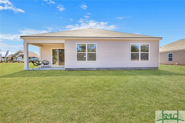 rear view of property featuring a lawn
