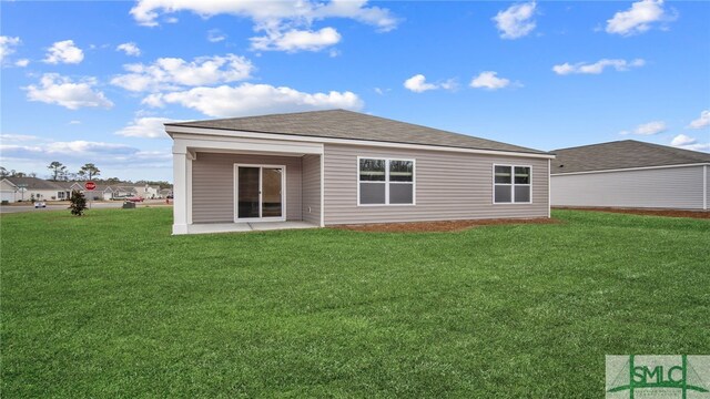 rear view of house with a lawn and a patio