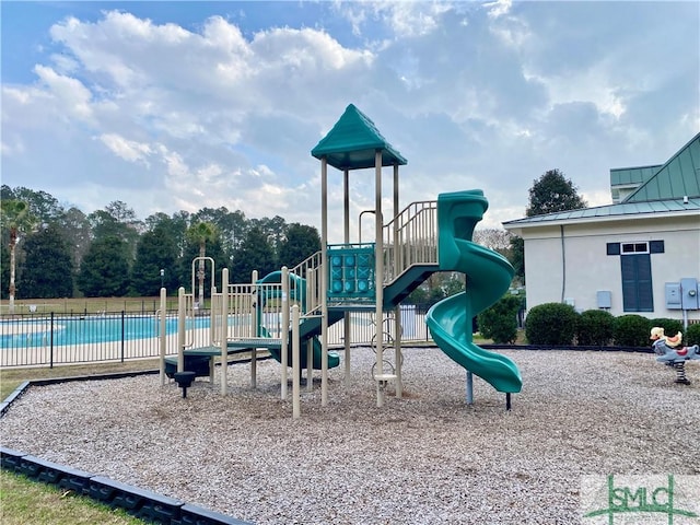 communal playground featuring fence and a community pool