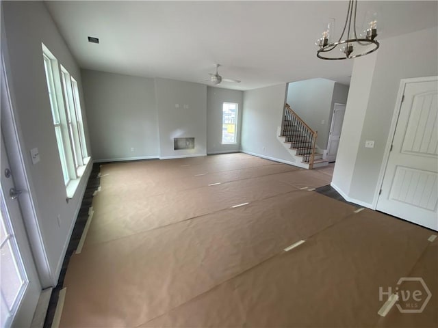 152 Como Dr, Pooler, GA 31322 - unfurnished living room with a ceiling fan, stairs, and a chandelier