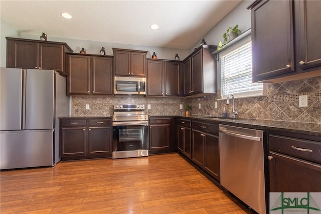 126 NE Owens St, Ludowici, GA 31316 - kitchen with dark brown cabinetry, stainless steel appliances, light wood-type flooring, and a sink