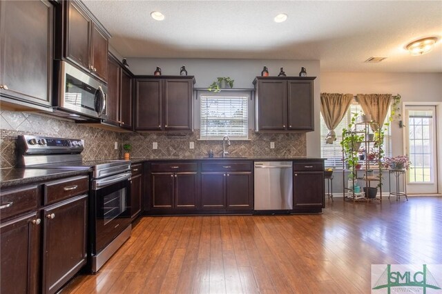 126 NE Owens St, Ludowici, GA 31316 - kitchen featuring dark countertops, a healthy amount of sunlight, stainless steel appliances, and a sink