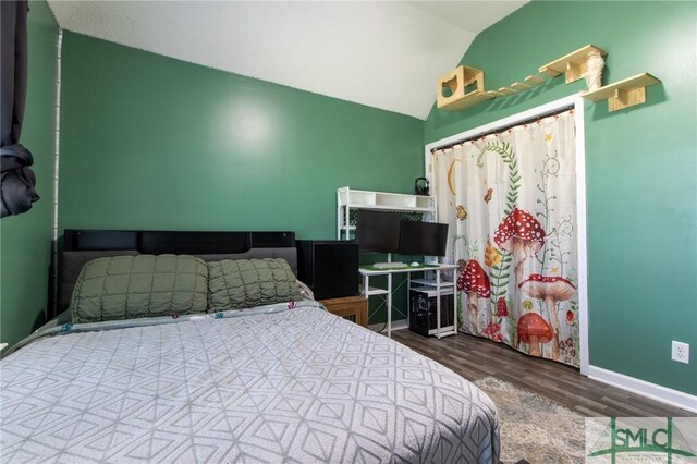 126 NE Owens St, Ludowici, GA 31316 - bedroom with wood finished floors, baseboards, and vaulted ceiling