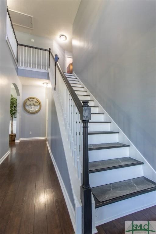 126 NE Owens St, Ludowici, GA 31316 - stairs with arched walkways, a towering ceiling, baseboards, and hardwood / wood-style floors