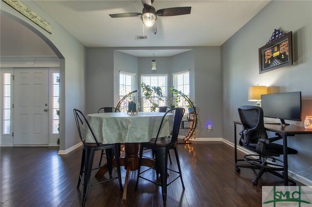 126 NE Owens St, Ludowici, GA 31316 - dining area featuring visible vents, arched walkways, baseboards, and dark wood-style floors