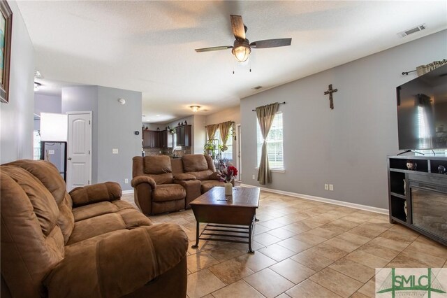 126 NE Owens St, Ludowici, GA 31316 - living area with light tile patterned floors, visible vents, baseboards, and ceiling fan