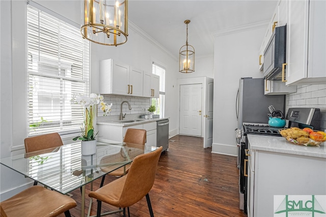 2210 Bull St, Savannah, GA 31401 - kitchen with a notable chandelier, ornamental molding, a sink, appliances with stainless steel finishes, and light countertops