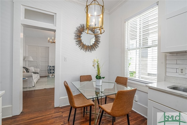 2210 Bull St, Savannah, GA 31401 - dining area featuring baseboards, dark wood-type flooring, a notable chandelier, and ornamental molding