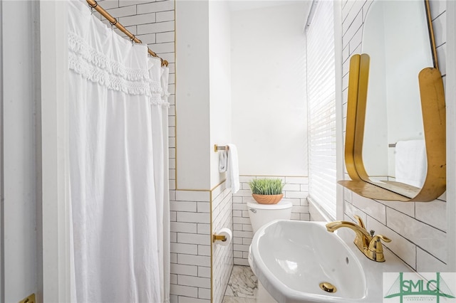 2210 Bull St, Savannah, GA 31401 - bathroom featuring a wainscoted wall, toilet, a shower with curtain, tile walls, and a sink