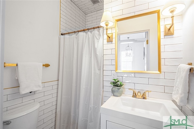 2210 Bull St, Savannah, GA 31401 - full bathroom with visible vents, toilet, vanity, a shower with curtain, and tile walls