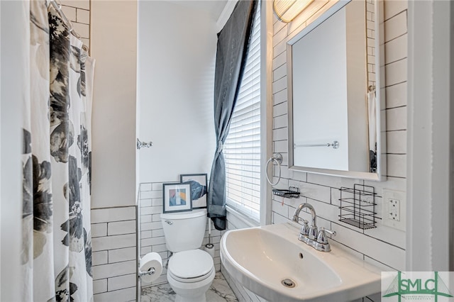 2210 Bull St, Savannah, GA 31401 - bathroom with tile walls, toilet, marble finish floor, and a sink