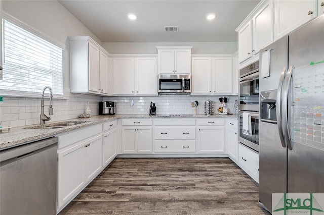 55 Saddlebrush Rd, Ellabell, GA 31308 - kitchen with white cabinetry, backsplash, dark wood-type flooring, appliances with stainless steel finishes, and a sink