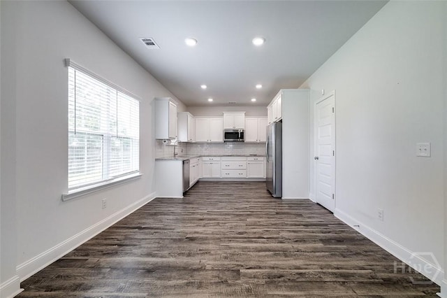 55 Saddlebrush Rd, Ellabell, GA 31308 - kitchen featuring stainless steel appliances, dark wood finished floors, white cabinetry, light countertops, and backsplash