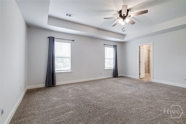 55 Saddlebrush Rd, Ellabell, GA 31308 - empty room featuring a tray ceiling, light colored carpet, plenty of natural light, and a ceiling fan