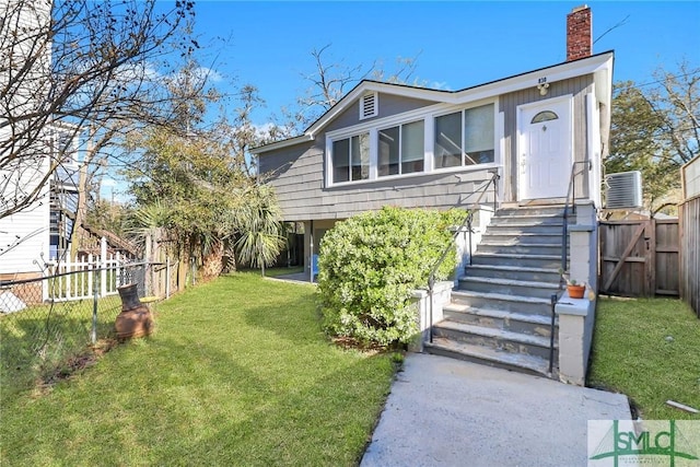 view of front of house featuring a front yard, fence, and a chimney