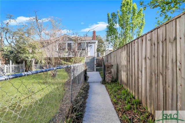 view of yard with a fenced front yard, stairway, and a gate