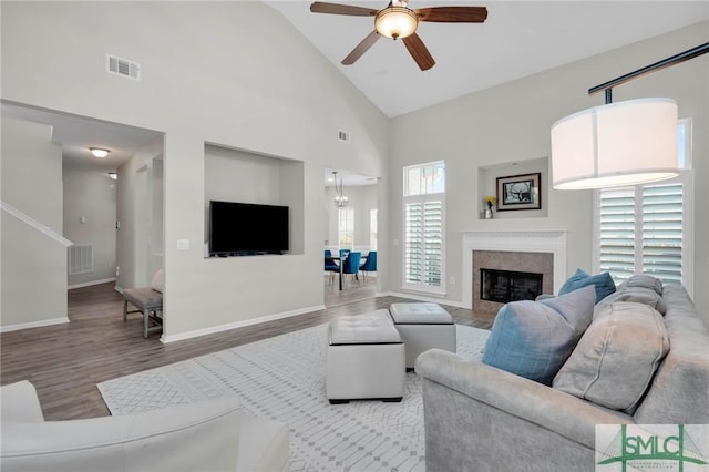 living area with visible vents, wood finished floors, high vaulted ceiling, and ceiling fan