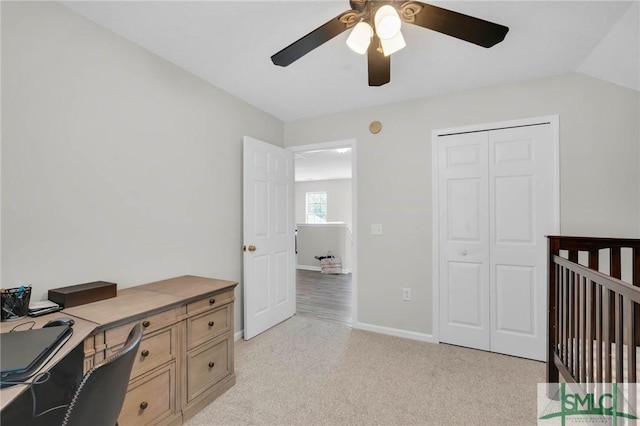 bedroom with light carpet, a closet, baseboards, ceiling fan, and vaulted ceiling
