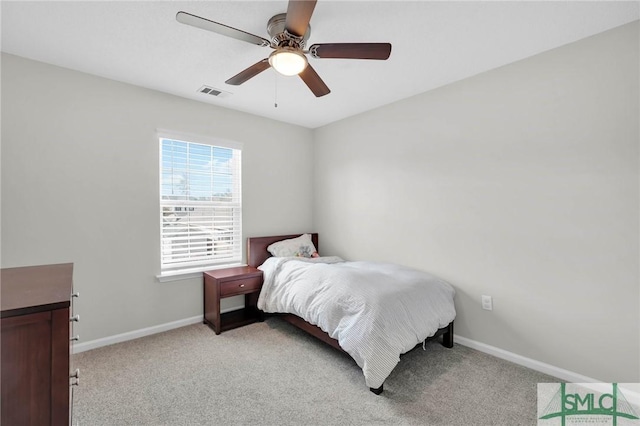 bedroom featuring visible vents, baseboards, light colored carpet, and a ceiling fan