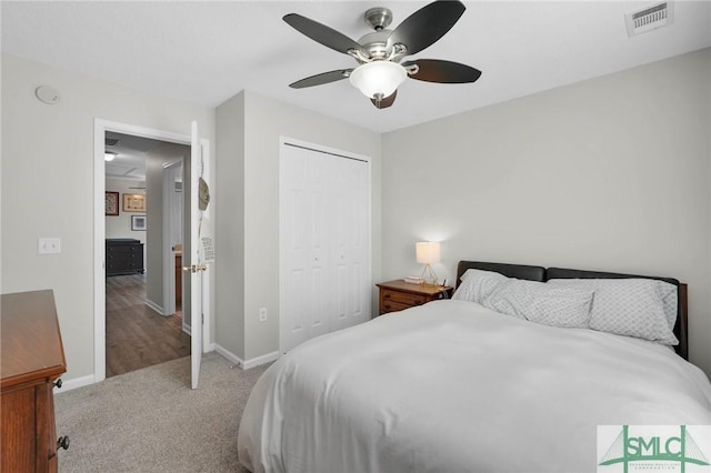 carpeted bedroom featuring visible vents, baseboards, a closet, and ceiling fan