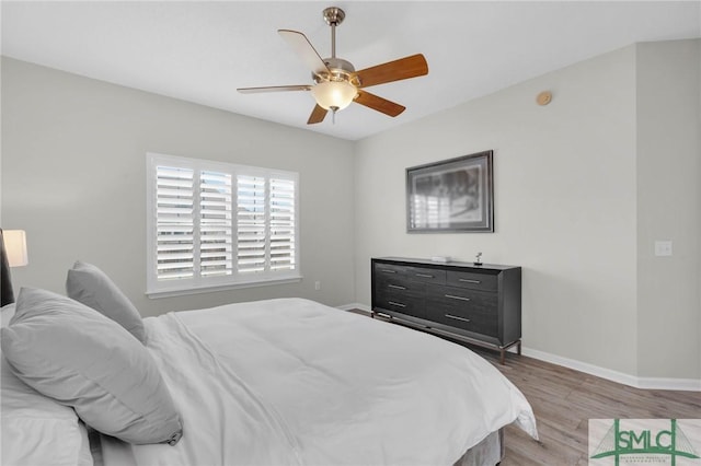 bedroom featuring ceiling fan, baseboards, and wood finished floors