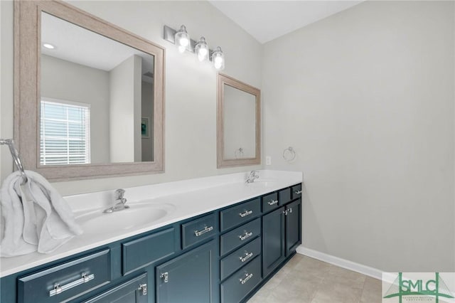 bathroom with double vanity, tile patterned flooring, baseboards, and a sink