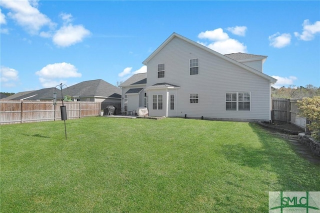 rear view of property with a lawn and a fenced backyard