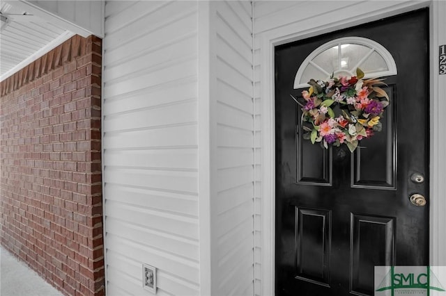view of exterior entry with brick siding