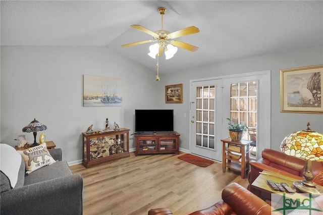 living room with a ceiling fan, lofted ceiling, wood finished floors, and baseboards