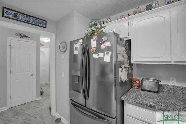 kitchen with white cabinets, stainless steel refrigerator with ice dispenser, marble finish floor, and a textured ceiling