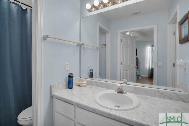 bathroom with visible vents, toilet, and vanity