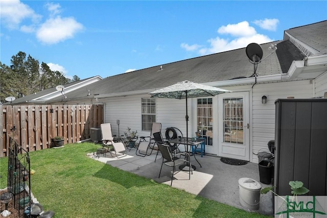 rear view of house with a yard, a patio, and fence