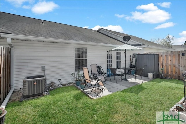 rear view of house with cooling unit, a patio, a lawn, and fence