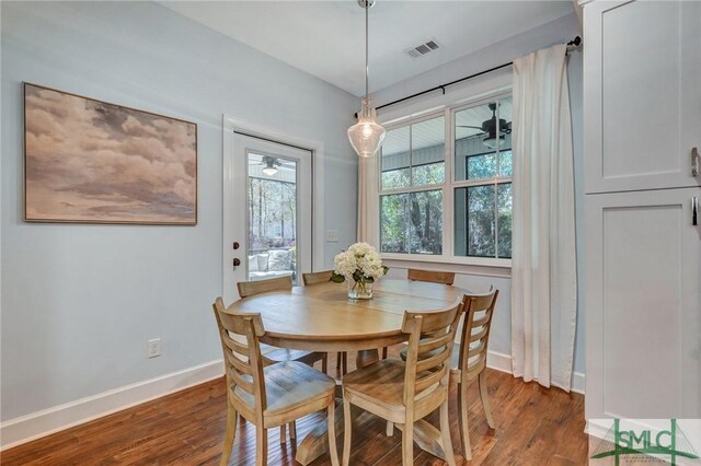 dining space featuring wood finished floors, visible vents, and baseboards