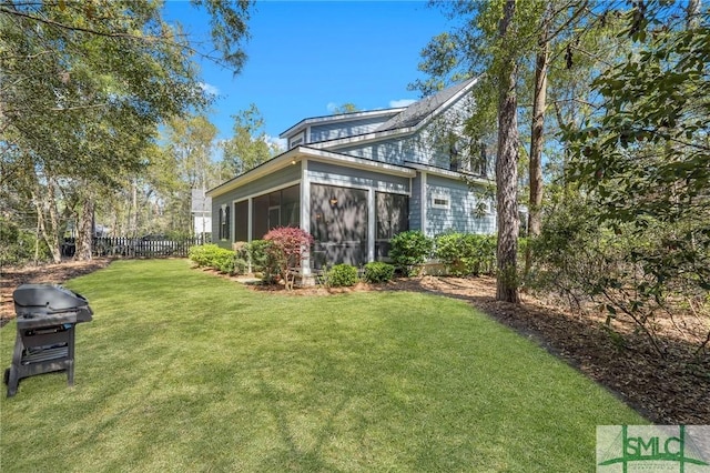 back of house with a sunroom, a lawn, and fence