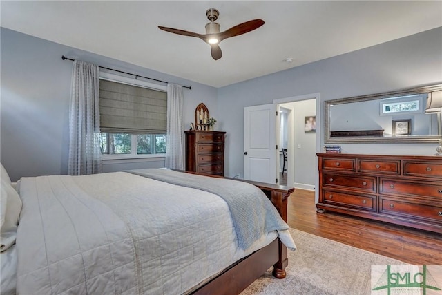 bedroom with baseboards, wood finished floors, and ceiling fan