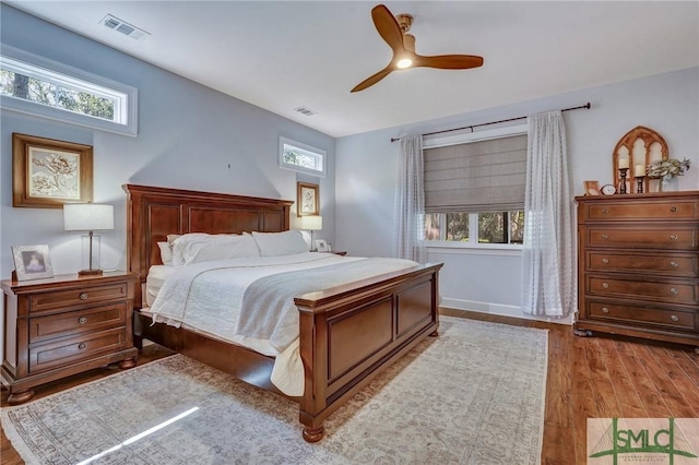 bedroom featuring visible vents, multiple windows, and light wood-style flooring