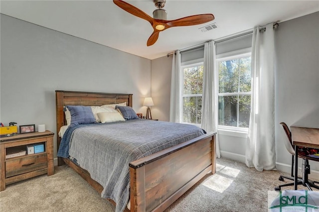 bedroom with visible vents, a ceiling fan, baseboards, and light carpet