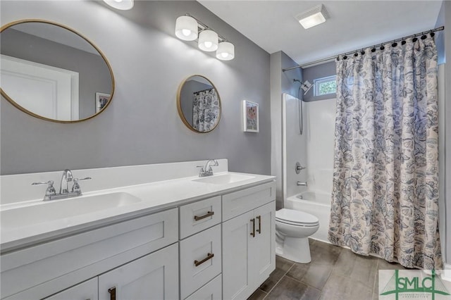 bathroom with toilet, double vanity, a sink, and shower / tub combo