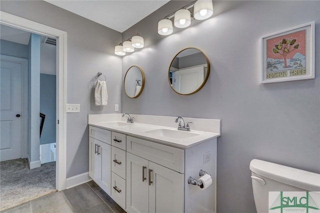full bath with double vanity, visible vents, toilet, and a sink