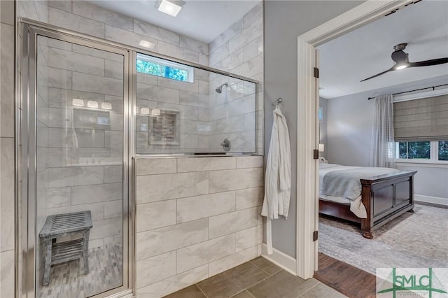 ensuite bathroom with baseboards, a stall shower, ceiling fan, and ensuite bathroom