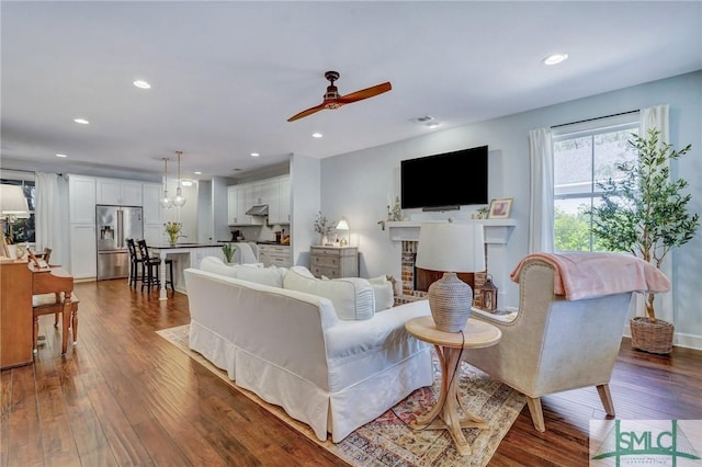 living area featuring dark wood-style floors, recessed lighting, ceiling fan, and a fireplace