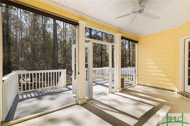 unfurnished sunroom with ceiling fan